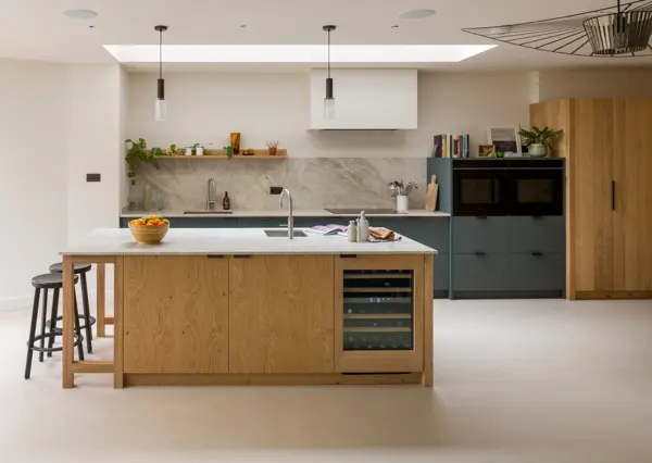 A bespoke handcrafted kitchen in Crouch End, London featuring raw band-sawn oak and smokey green Verde Comodoro Fenix cabinetry.