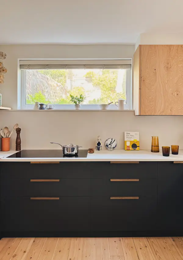 Richlite kitchen cabinetry paired with brass handles and concrete quartz worktops