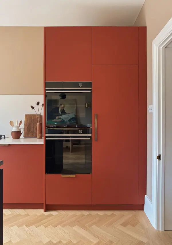 An integrated fridge hidden behind red Fenix doors