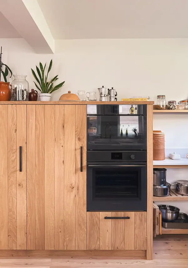 Kitchen appliances beautifully integrated into a bank of oak cabinetry