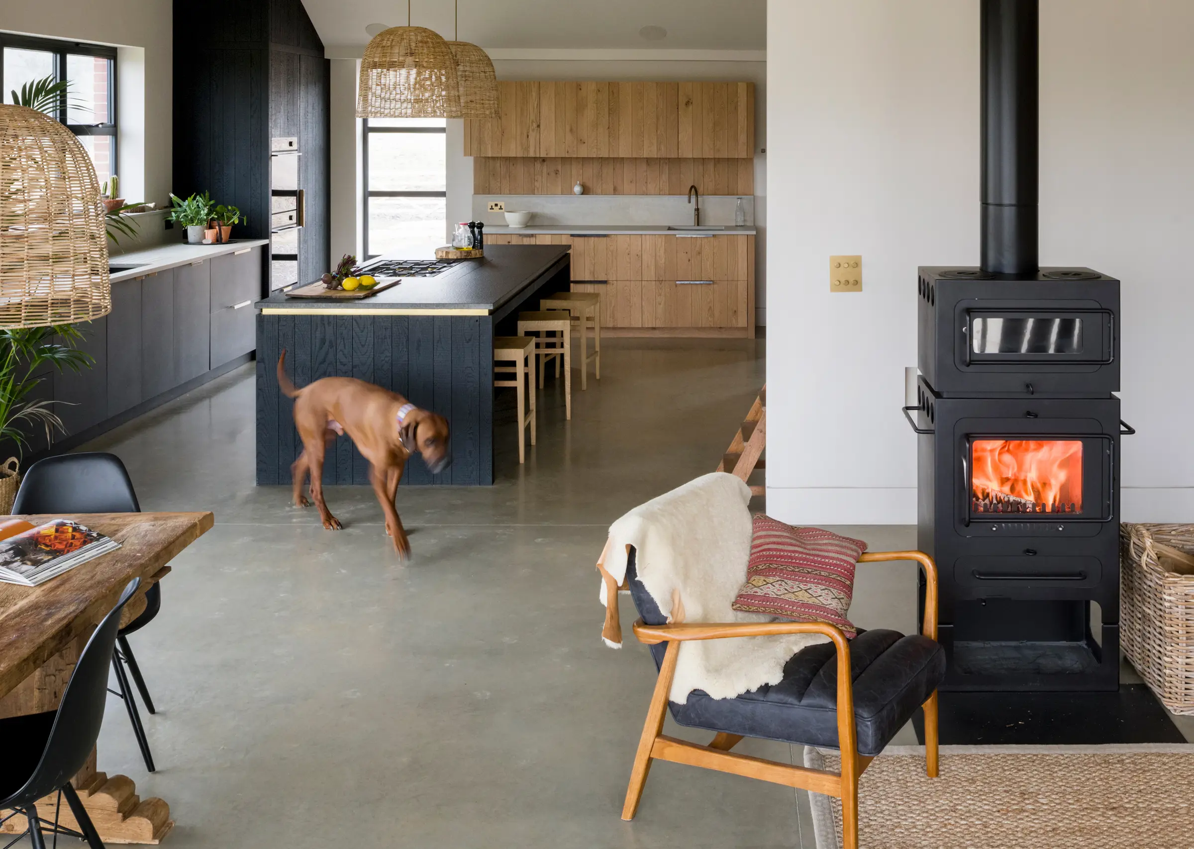 A large open plan kitchen and living space made warm and cosy with lots of texture including band-sawn oak in different tones and a social kitchen island for prep and cooking whilst remaining part of a gathering.