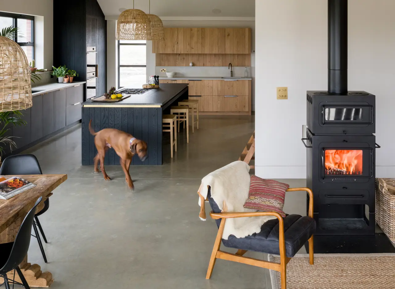 A large open plan kitchen and living space made warm and cosy with lots of texture including band-sawn oak in different tones and a social kitchen island for prep and cooking whilst remaining part of a gathering.