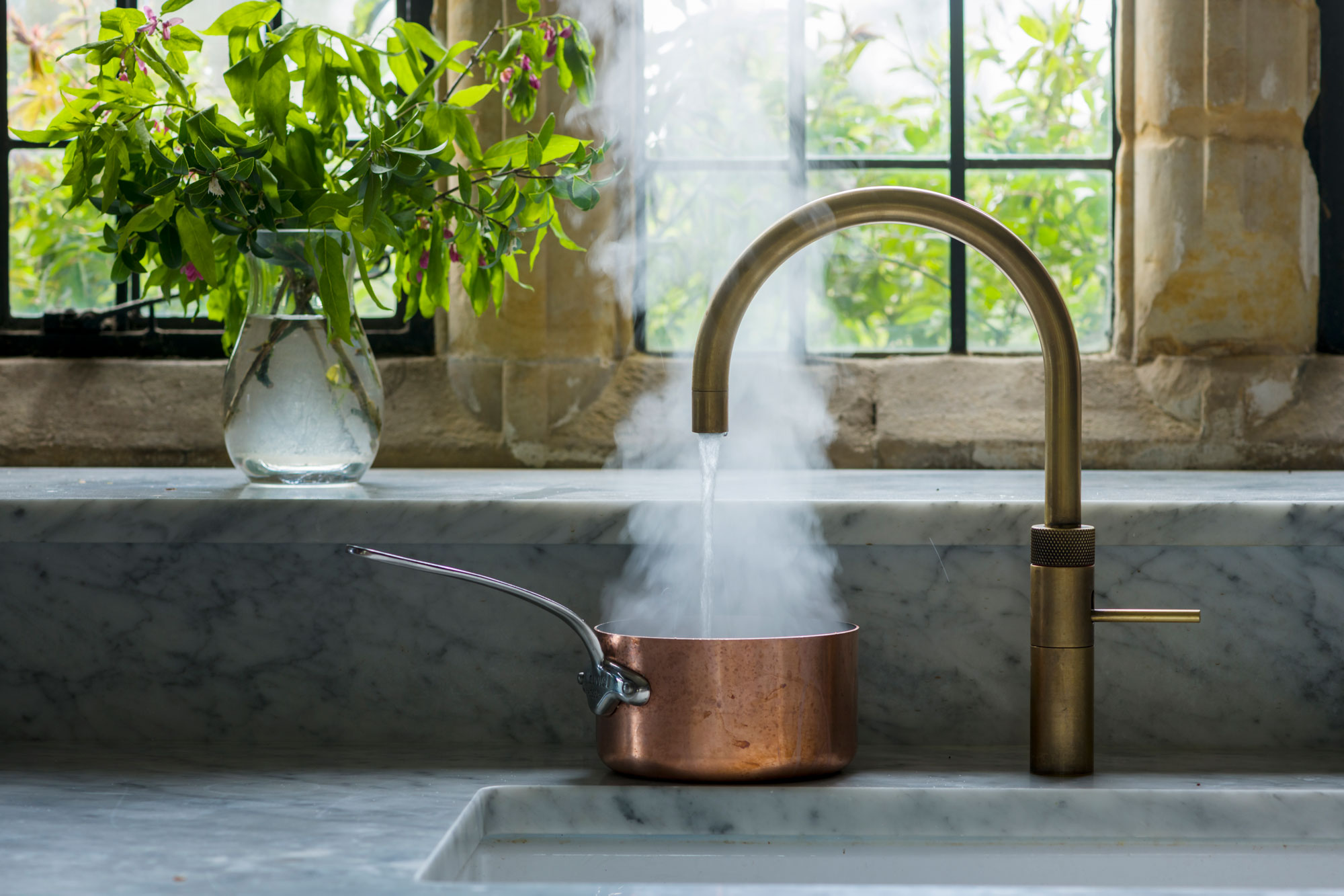 Kitchen tap with steaming copper saucepan